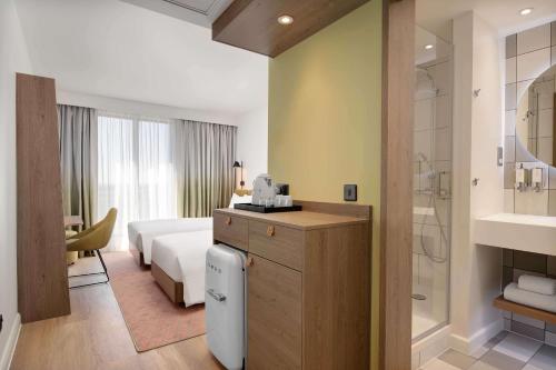 a hotel room with a bed and a bathroom at Hampton by Hilton High Wycombe in High Wycombe
