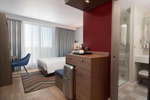 a hotel room with a bed and a bathroom at Hampton by Hilton High Wycombe in High Wycombe
