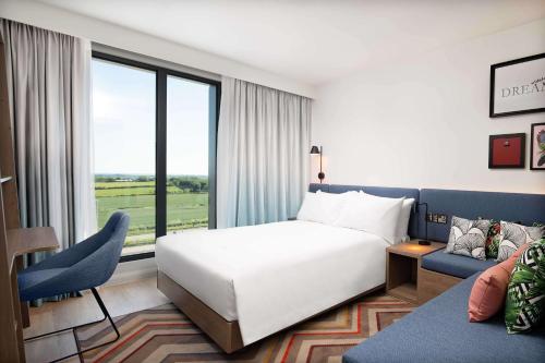a hotel room with a bed and a couch at Hampton by Hilton High Wycombe in High Wycombe