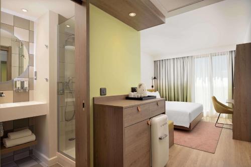 a hotel room with a bed and a bathroom at Hampton by Hilton High Wycombe in High Wycombe