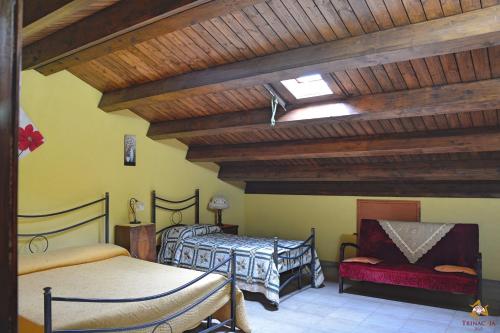ランダッツォにあるB&B Trinacriaの木製の天井が特徴のベッドルーム1室(ベッド2台付)
