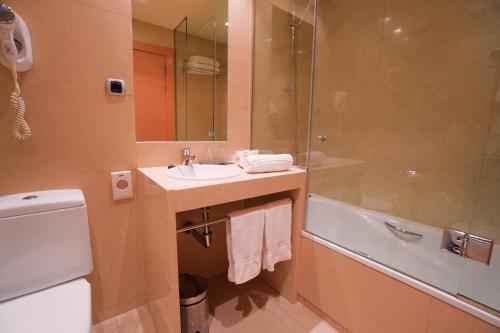 a bathroom with a sink and a shower and a toilet at Hotel Reston Valdemoro in Valdemoro