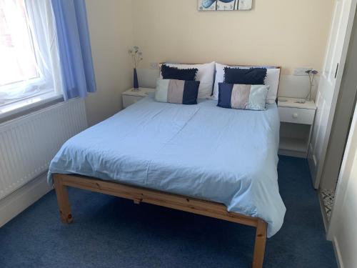 a bedroom with a large bed with blue sheets and pillows at Marlow Lodge in Blackpool