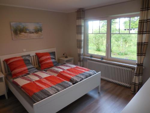 Friedeburg的住宿－Salthuus Ostfriesland，一间卧室设有一张床和两个窗户。
