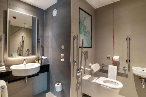 a bathroom with a toilet and a sink at Hilton Garden Inn London Heathrow Terminal 2 and 3 in Hillingdon