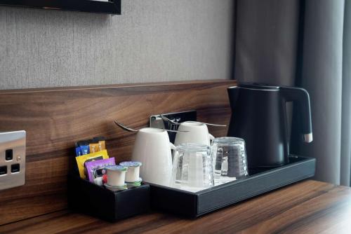 a tray with paper towels and a coffee maker on a counter at Hilton Garden Inn London Heathrow Terminal 2 and 3 in Hillingdon