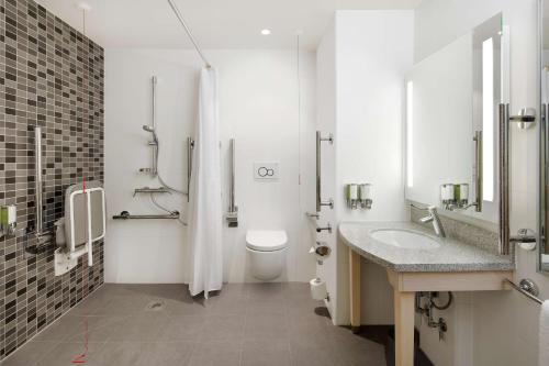 bagno bianco con servizi igienici e lavandino di Hampton By Hilton London Docklands a Londra