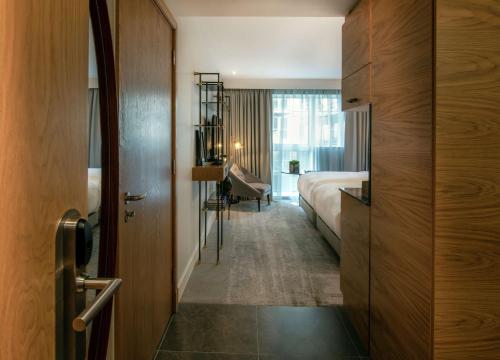a hotel room with a bed and a desk at Lincoln Plaza Hotel London, Curio Collection By Hilton in London