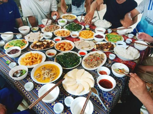 a group of people sitting around a table full of food at Tày Cốc Pảng Homestay in Làng Cac