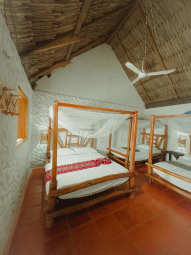 two bunk beds in a room with a ceiling at Praba Hostel in Palomino