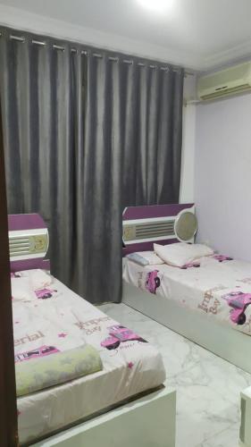 2 łóżka w pokoju z zasłoną w obiekcie بلطيم w mieście Al Ḩammād