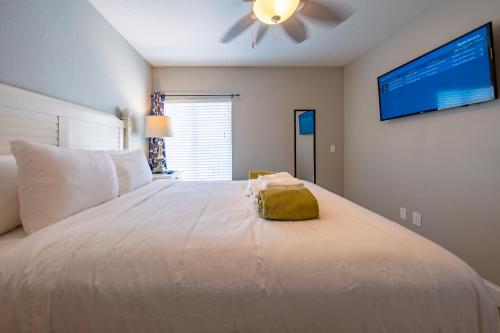 a bedroom with a large white bed with a ceiling fan at Emerald on the Water - Formerly Belleair Beach Club in Clearwater Beach