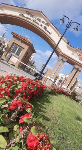 a building with a bunch of red flowers in the grass at بلطيم in Al Ḩammād