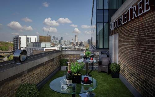 einen Balkon mit zwei Tischen auf einem Gebäude in der Unterkunft Doubletree By Hilton London - Greenwich in London