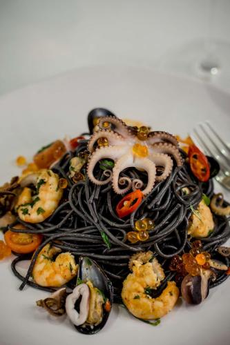 a pasta dish with an octopus and shrimp on a plate at Doubletree By Hilton London - Greenwich in London