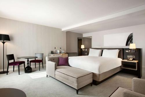 a hotel room with a bed and a chair and a table at Hilton London Angel Islington in London