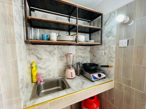 um balcão de cozinha com um lavatório e um liquidificador em Happy House Nungwi em Nungwi
