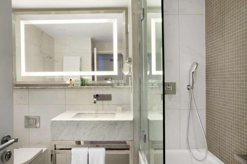 a white bathroom with a sink and a shower at Hilton London Angel Islington in London