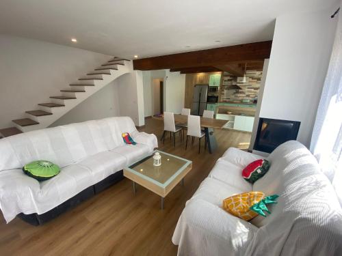 ein Wohnzimmer mit 2 weißen Sofas und einem Tisch in der Unterkunft Casa Libélula in Castelló d'Empúries