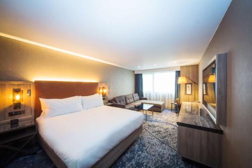 a hotel room with a bed and a living room at DoubleTree by Hilton London Kingston Upon Thames in Kingston upon Thames