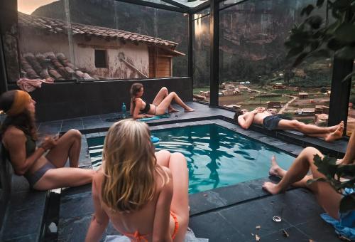 a group of people sitting around a swimming pool at Wolf Totem Steam Punk Loft Villa in Pisac