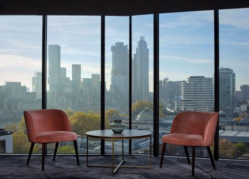 2 chaises et une table devant une fenêtre dans l'établissement The Westminster London, Curio Collection by Hilton, à Londres