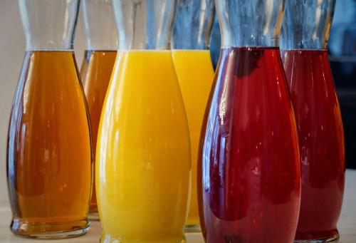 a row of different colored vases sitting on a table at The Westminster London, Curio Collection by Hilton in London
