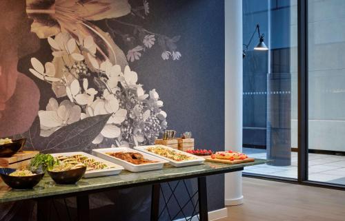 a buffet with several trays of food on a table at The Westminster London, Curio Collection by Hilton in London