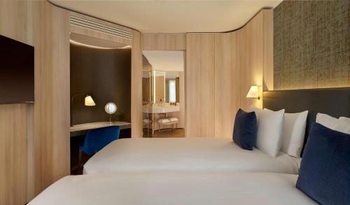 a bedroom with a large white bed with blue pillows at The Westminster London, Curio Collection by Hilton in London
