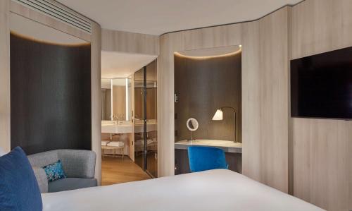 a hotel room with a bed and a television at The Westminster London, Curio Collection by Hilton in London