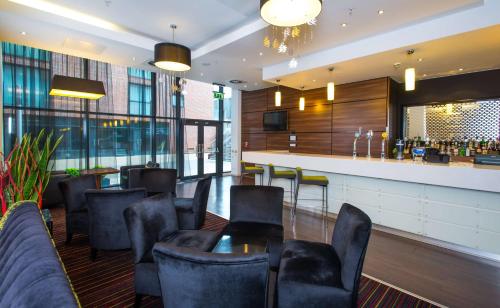 um restaurante com mesa e cadeiras e um bar em Hampton By Hilton Liverpool City Centre em Liverpool