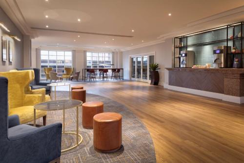 a living room with a yellow couch and a table at DoubleTree by Hilton Stoke-on-Trent, United Kingdom in Stoke on Trent