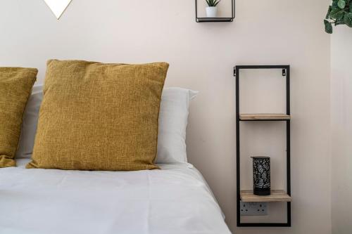 a bed with a yellow pillow and a mirror at Leicester City Center The Boat House Building in Leicester