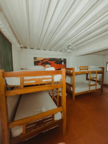a room with three bunk beds in a house at Praba Hostel in Palomino