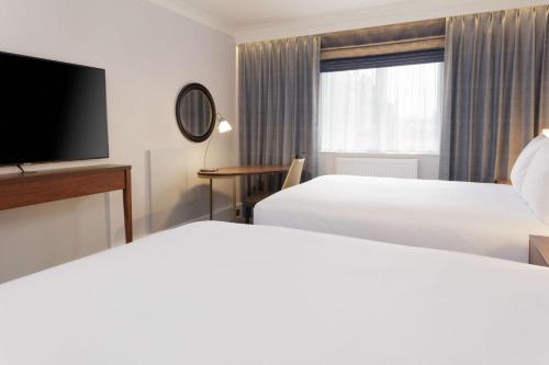 a hotel room with two beds and a flat screen tv at DoubleTree by Hilton Stoke-on-Trent, United Kingdom in Stoke on Trent
