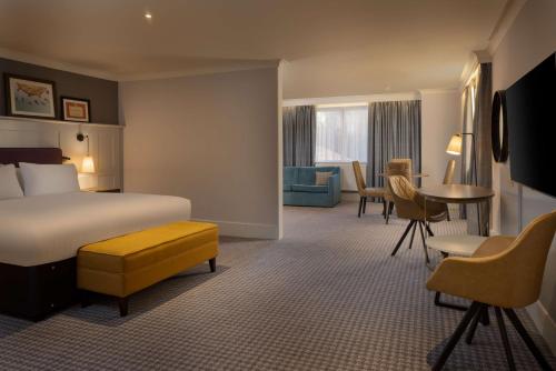 a hotel room with a bed and a table and chairs at DoubleTree by Hilton Stoke-on-Trent, United Kingdom in Stoke on Trent