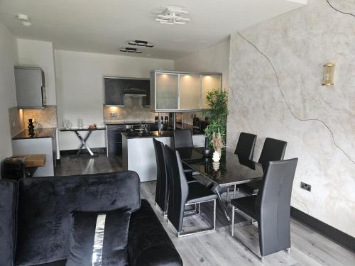 cocina y comedor con mesa y sillas en Centenary Apartments en Bradford