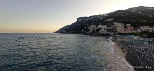 a beach with a bunch of people in the water at allafontanina in Minori