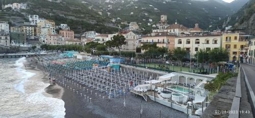 a beach with chairs and umbrellas and the water at allafontanina in Minori