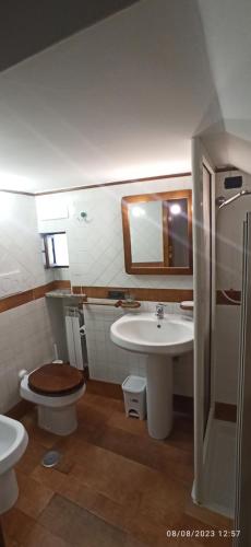 a bathroom with a sink and a toilet and a mirror at allafontanina in Minori