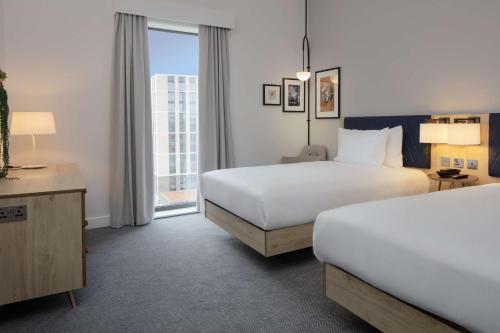 a hotel room with two beds and a window at Hilton Garden Inn Stoke On Trent in Stoke on Trent