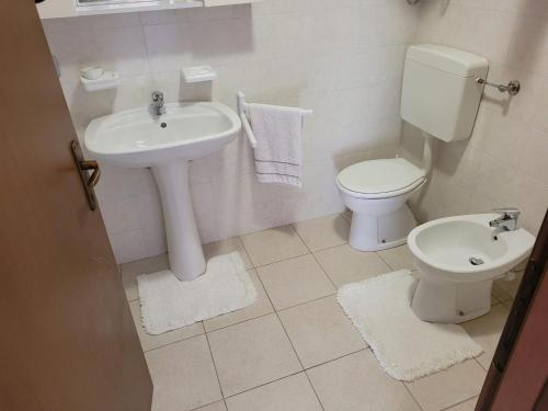 bagno bianco con servizi igienici e lavandino di Casa Ettore a Lizzola Alta