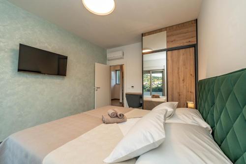 a bedroom with a bed with a tv on the wall at Villa Bajlo in Ždrelac