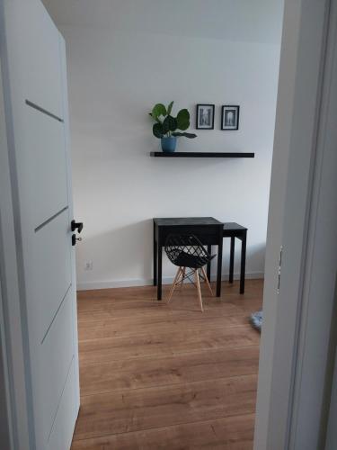 um corredor com uma mesa e uma cadeira num quarto em La Casa em Piotrków Trybunalski