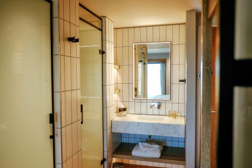 a bathroom with a sink and a mirror at IXORA Hotel & Spa Snowdonia in Conwy