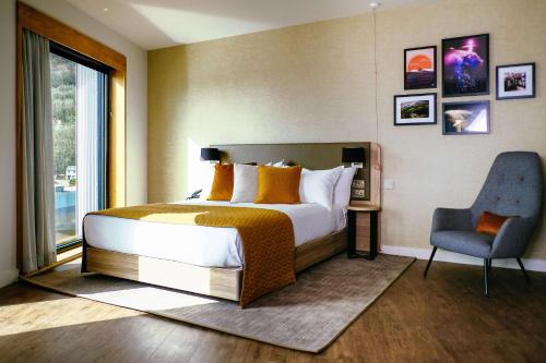 a bedroom with a bed and a chair and a window at IXORA Hotel & Spa Snowdonia in Conwy
