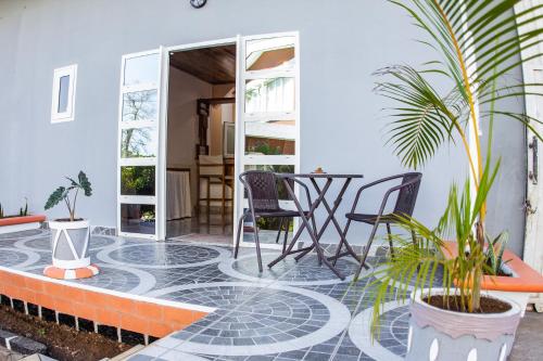 a patio with plants and a table and chairs at Cambria Hotel in Nosy Be