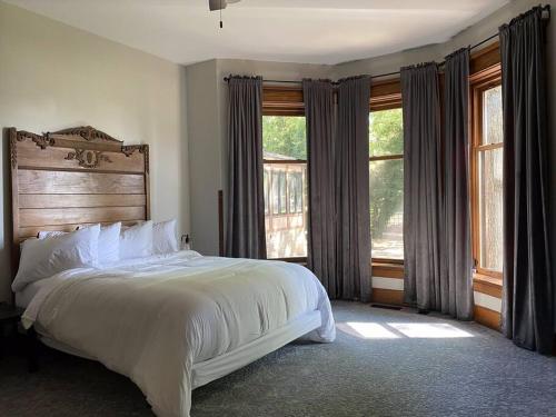 een slaapkamer met een groot wit bed en ramen bij Copperfield - 5 Bed/4 Bath in Centralia
