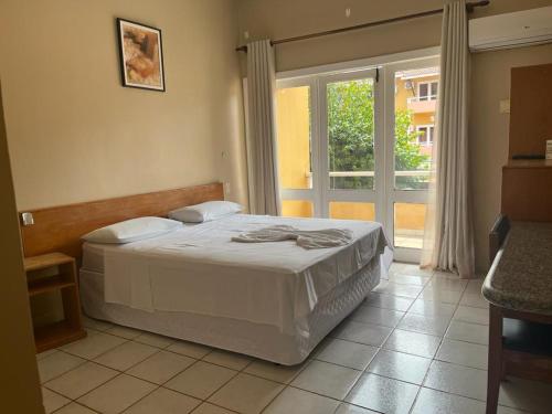 a bedroom with a bed and a large window at Hotel Uirapuru in Goianesia do Para