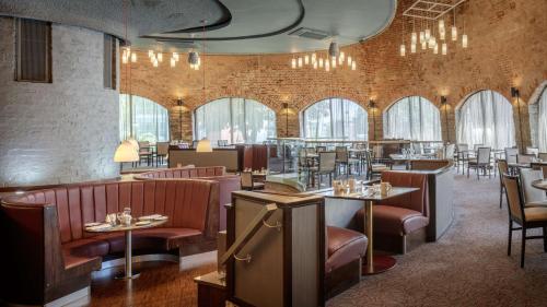 un restaurante con mesas, sillas y ventanas en DoubleTree by Hilton Bristol City Centre en Bristol